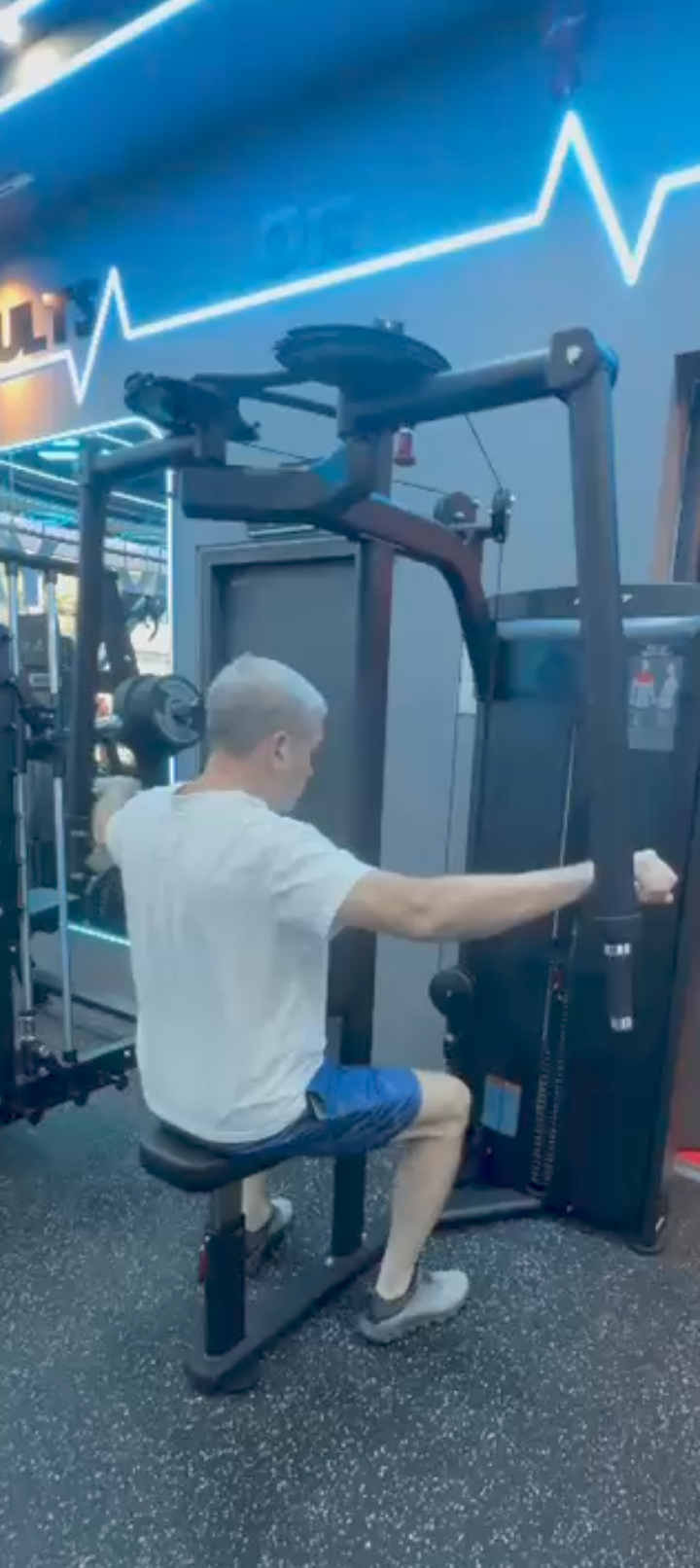 Senior man doing cable row exercise, strength training for older adults, gym workout over 60